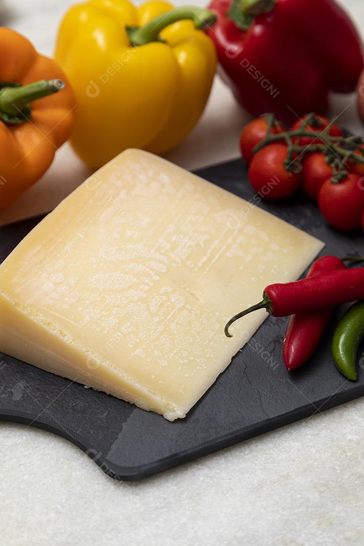 Queijo parmesão no tabuleiro de pedra preta com especiarias