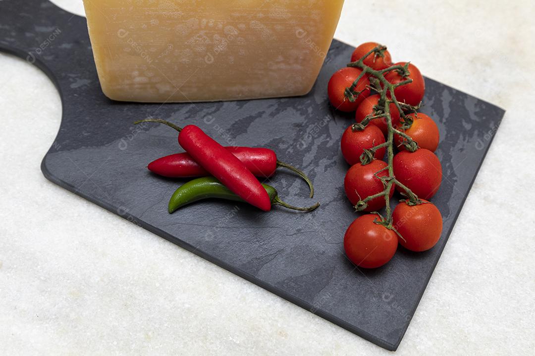 Queijo parmesão no tabuleiro de pedra preta com especiarias