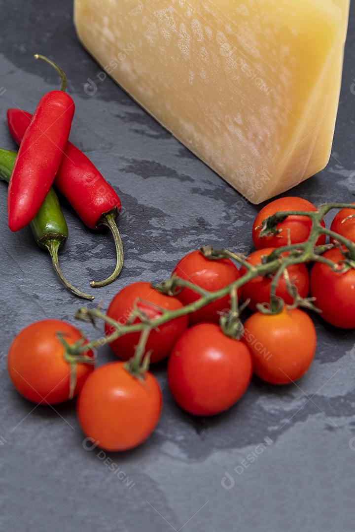 Queijo parmesão no tabuleiro de pedra preta com especiarias
