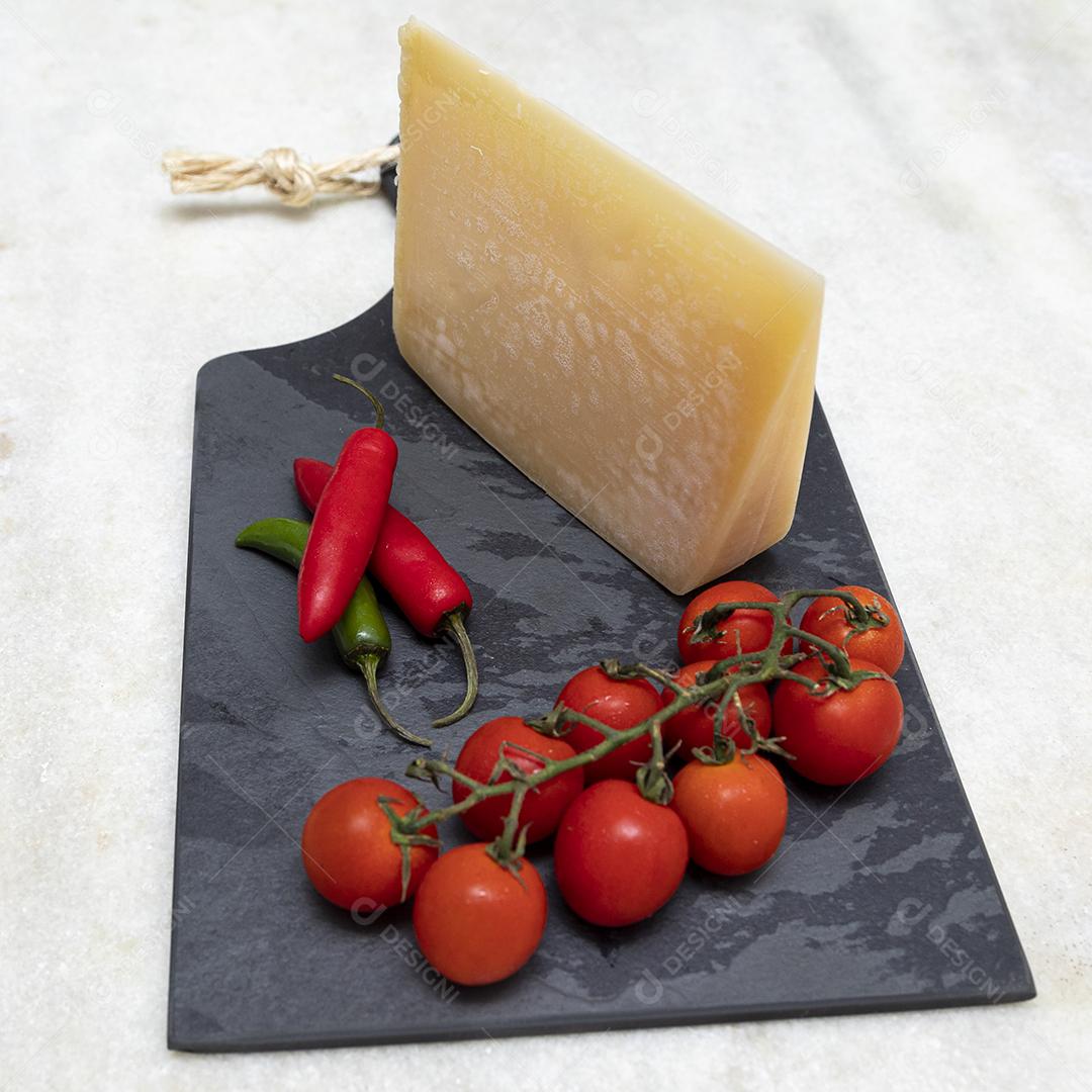 Queijo parmesão no tabuleiro de pedra preta com especiarias