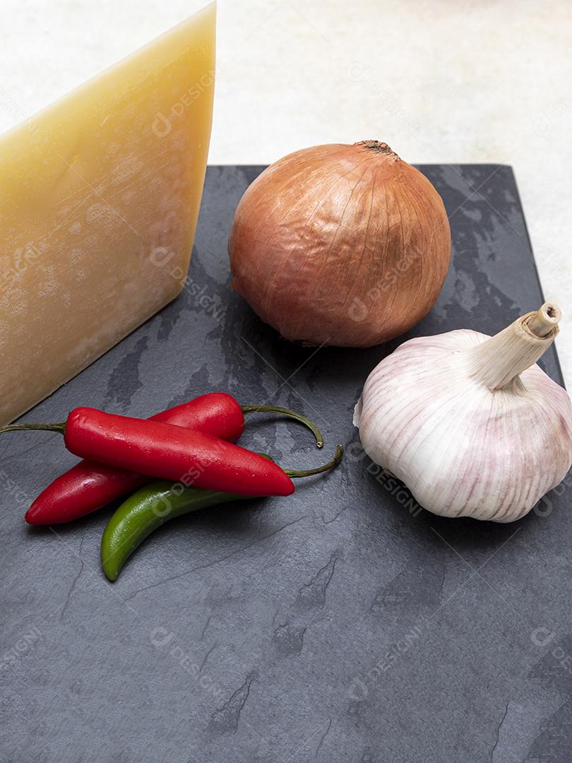 Queijo parmesão no tabuleiro de pedra preta com especiarias