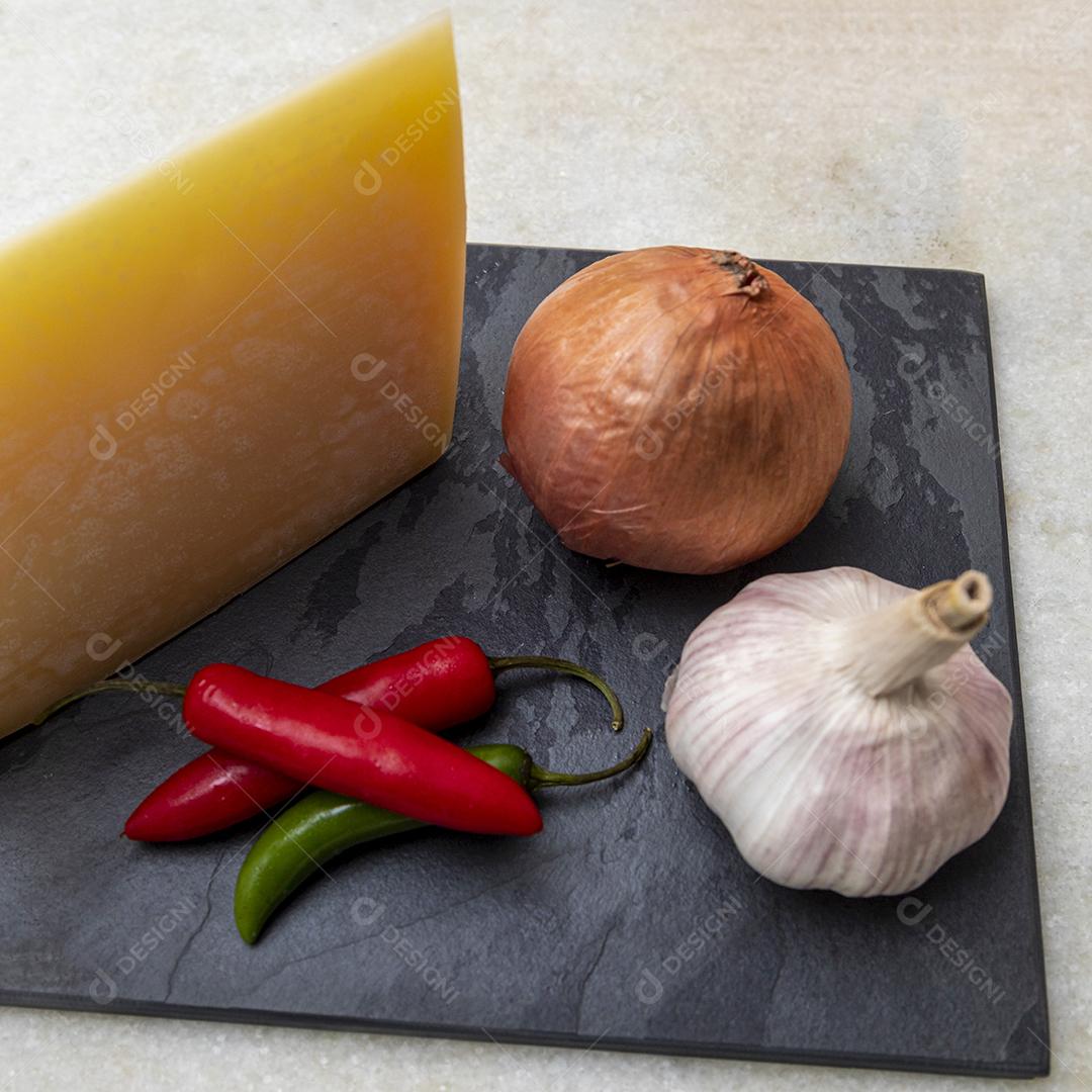 Queijo parmesão no tabuleiro de pedra preta com especiarias