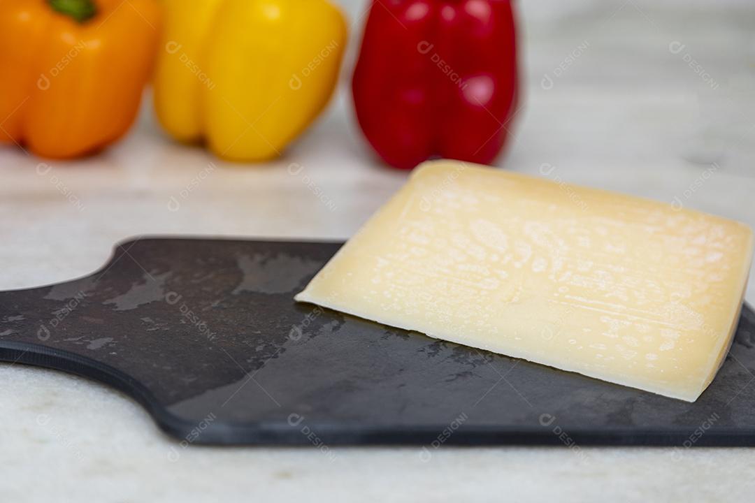 Queijo parmesão no tabuleiro de pedra preta com especiarias