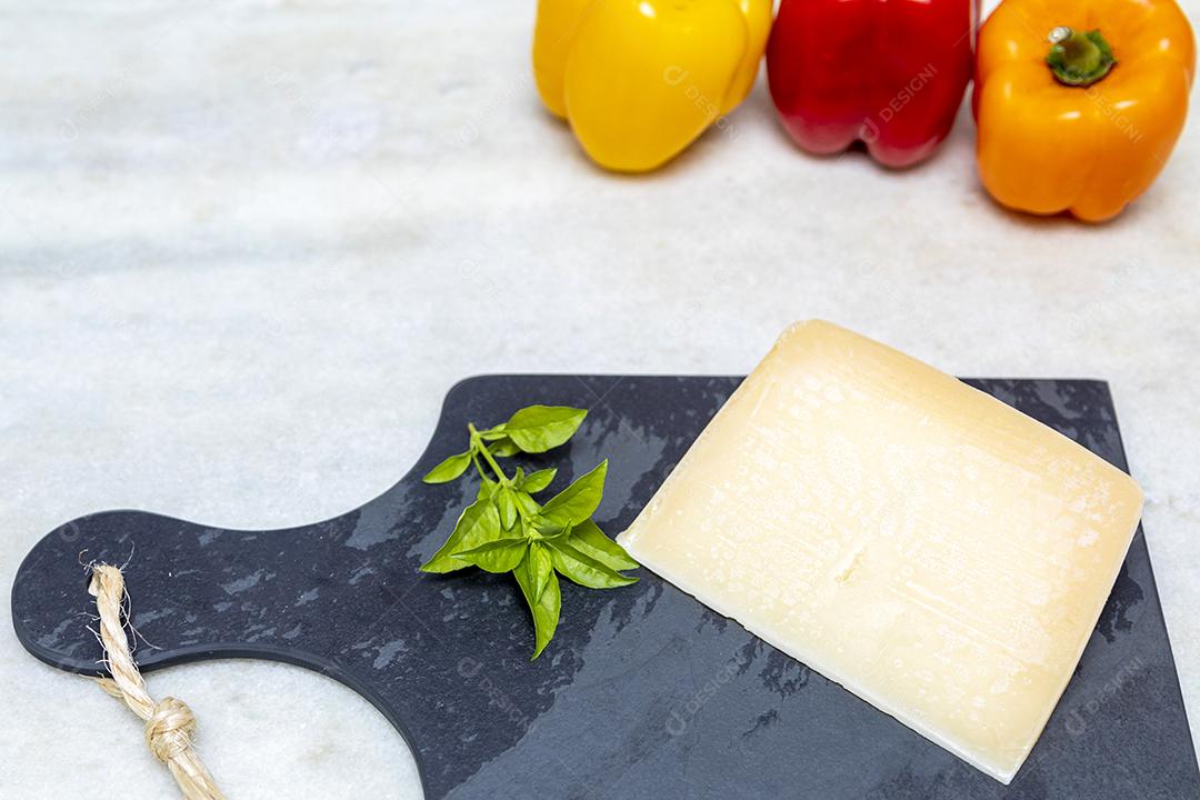 Queijo parmesão no tabuleiro de pedra preta com especiarias