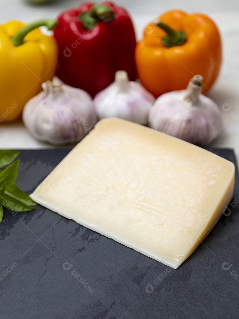 Queijo parmesão no tabuleiro de pedra preta com especiarias