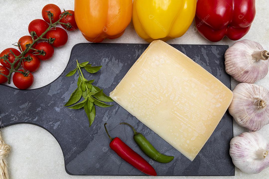 Queijo parmesão no tabuleiro de pedra preta com especiarias