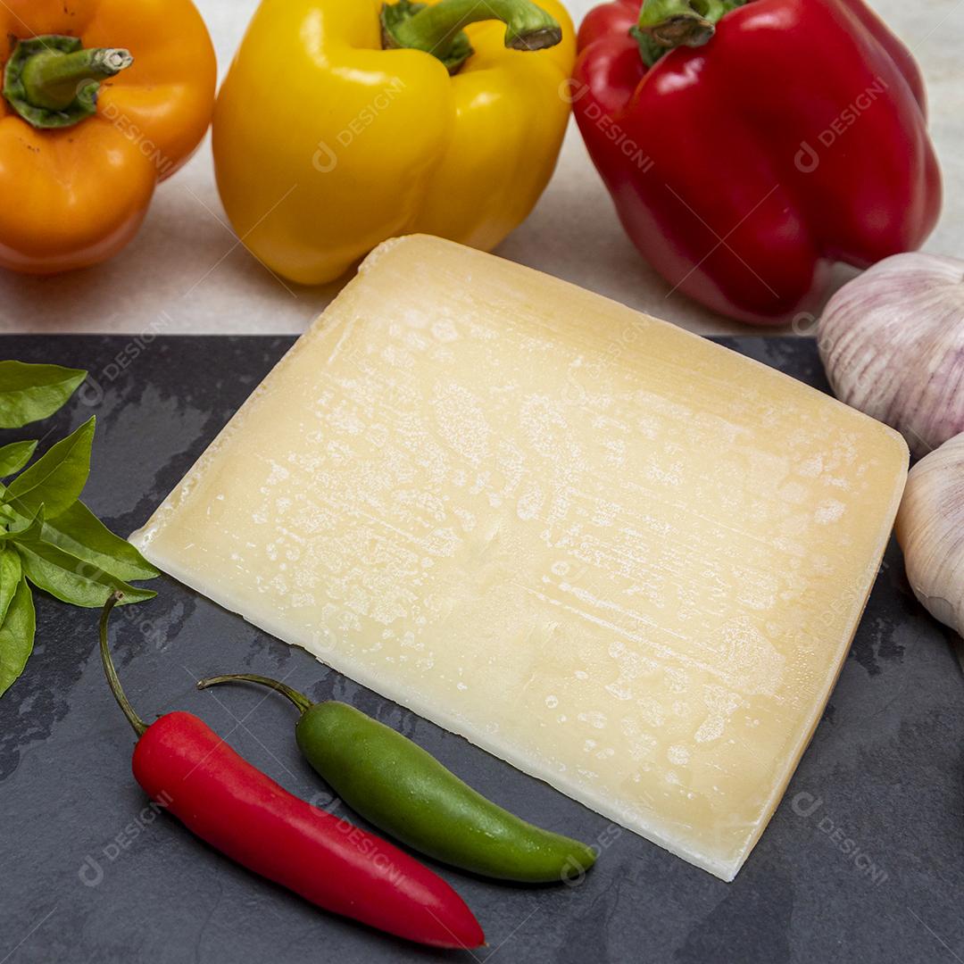 Queijo parmesão no tabuleiro de pedra preta com especiarias