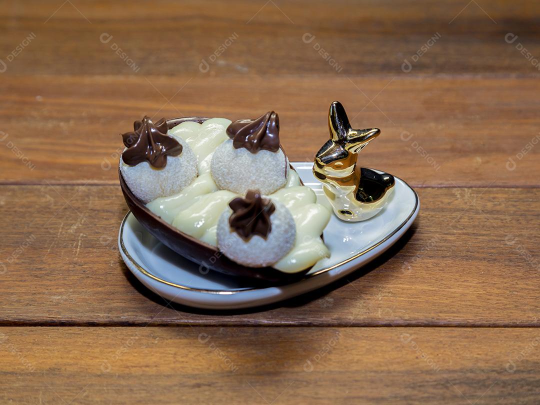 Ovos de Páscoa de chocolate em tigela com coelho de porcelana Imagem JPG