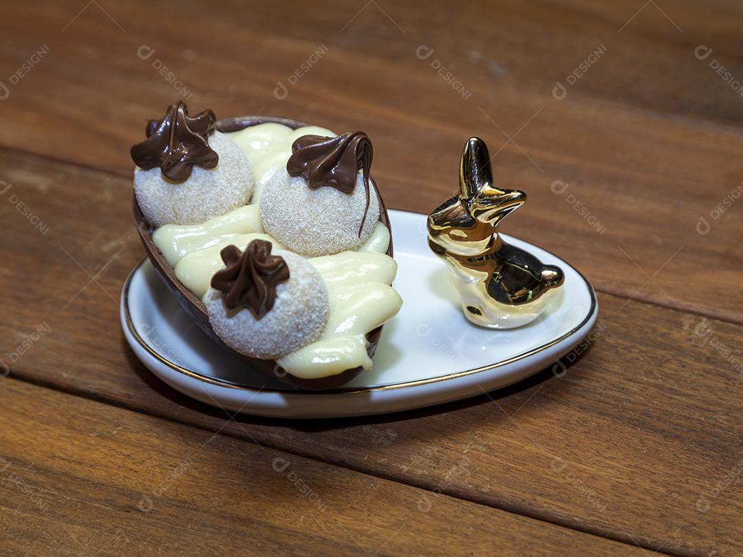 Ovos de Páscoa de chocolate em tigela com coelho de porcelana Imagem JPG
