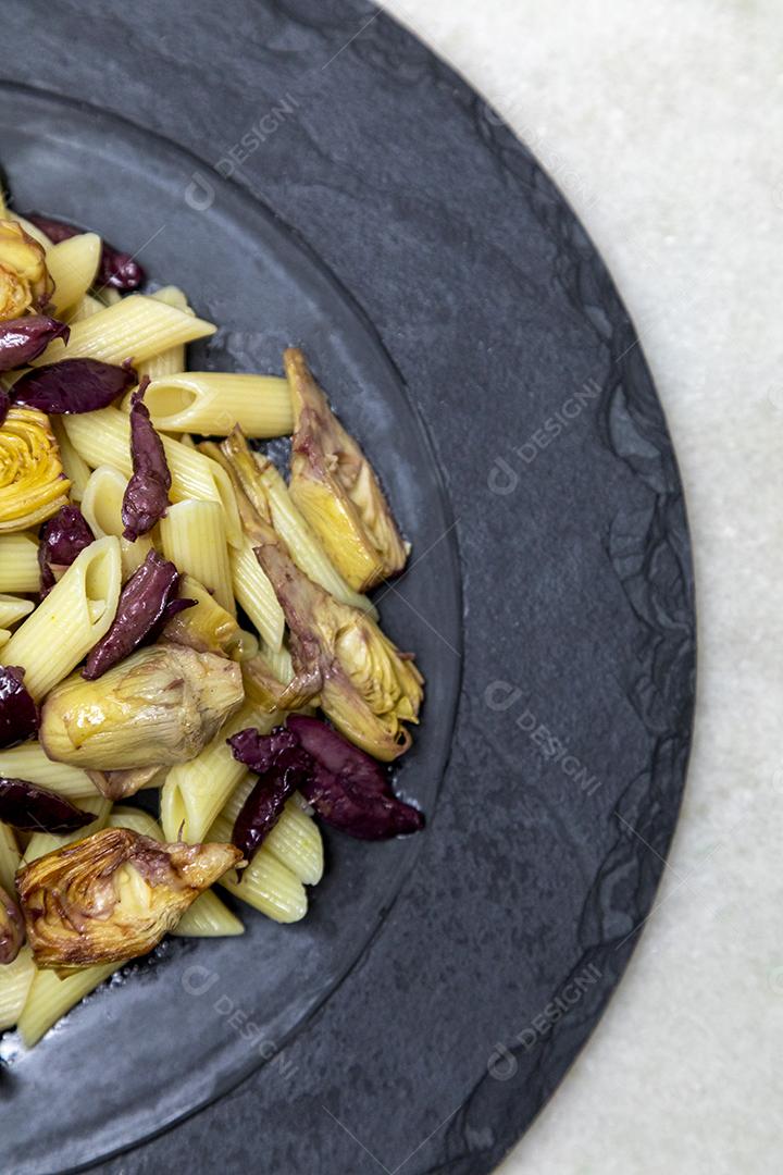 Massa com azeitonas pretas e corações de alcachofra, coberto com fresco