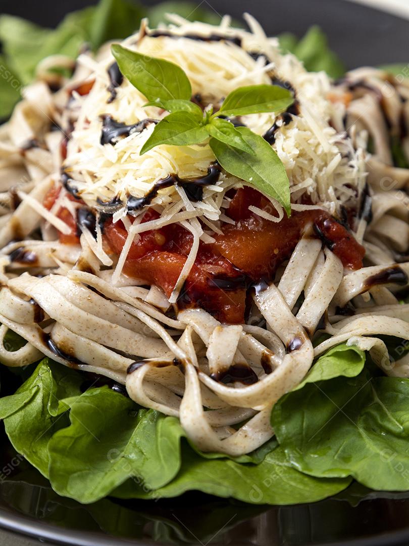 massa de massa integral com queijo parmesão, folhas verdes de rúcula