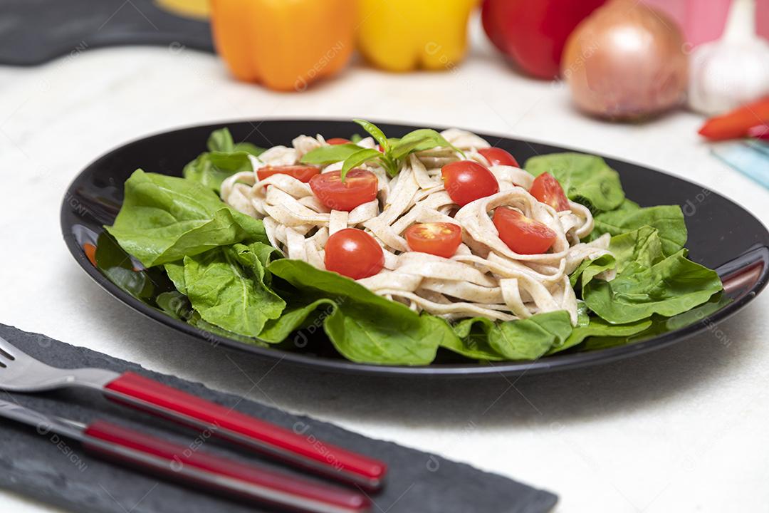 Massa integral com folhas verdes de rúcula e tomate cereja