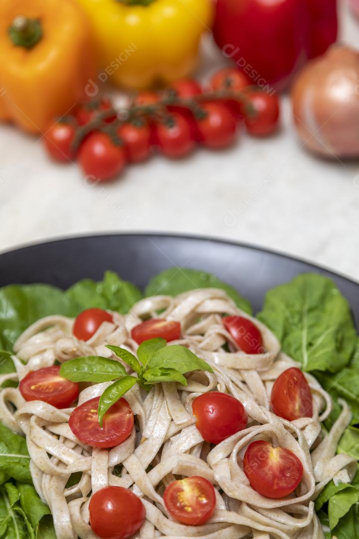 Massa integral com folhas verdes de rúcula e tomate cereja