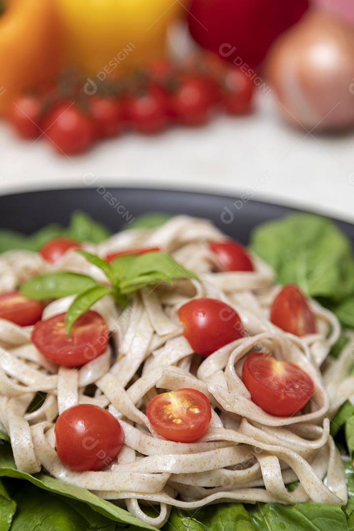 Massa integral com folhas verdes de rúcula e tomate cereja