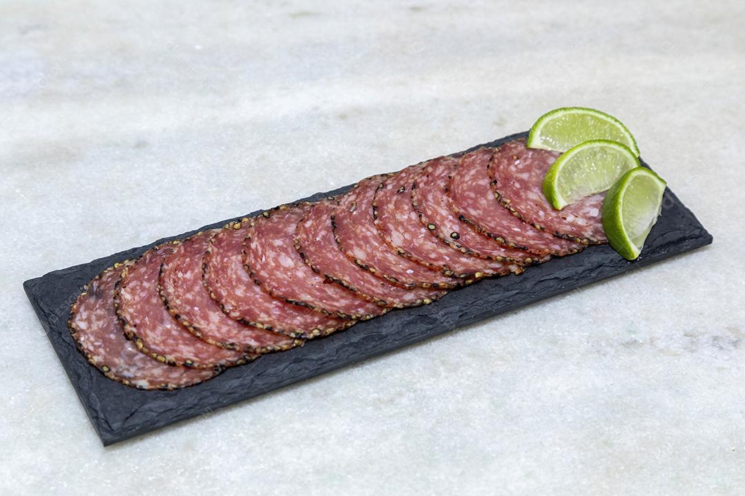 Porção de salame em placa de pedra preta JPG