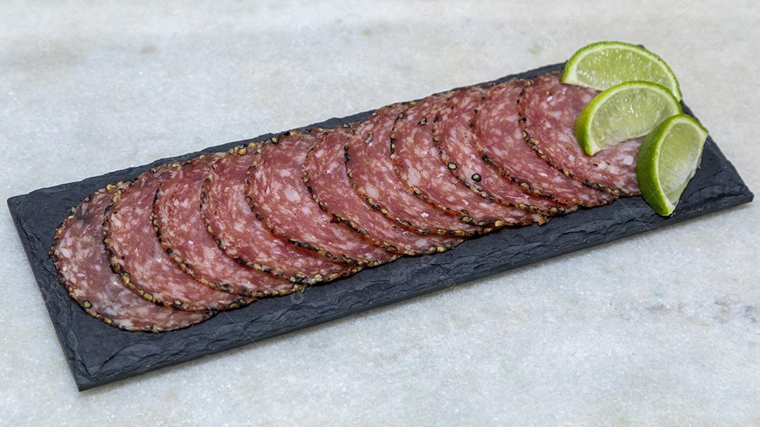 Porção de salame em placa de pedra preta JPG