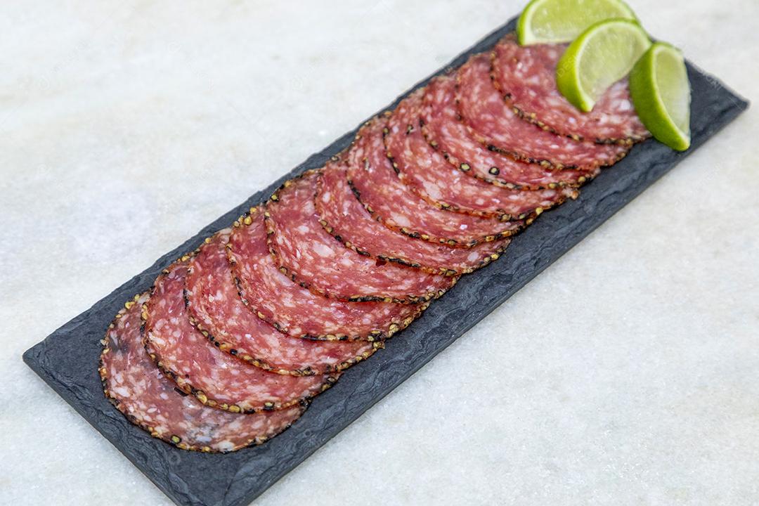 Porção de salame em placa de pedra preta JPG