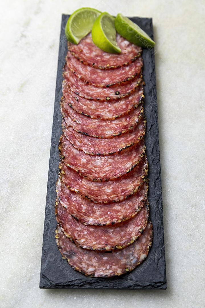 Porção de salame em placa de pedra preta JPG