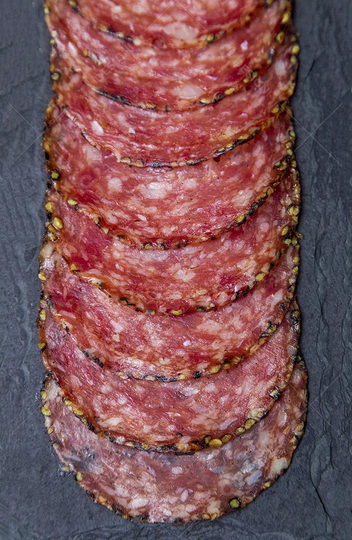 Porção de salame em placa de pedra preta JPG