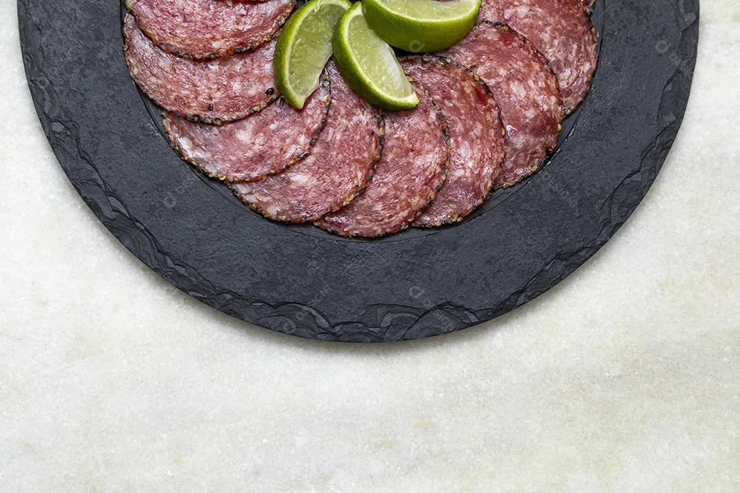 Porção de salame em placa de pedra preta JPG