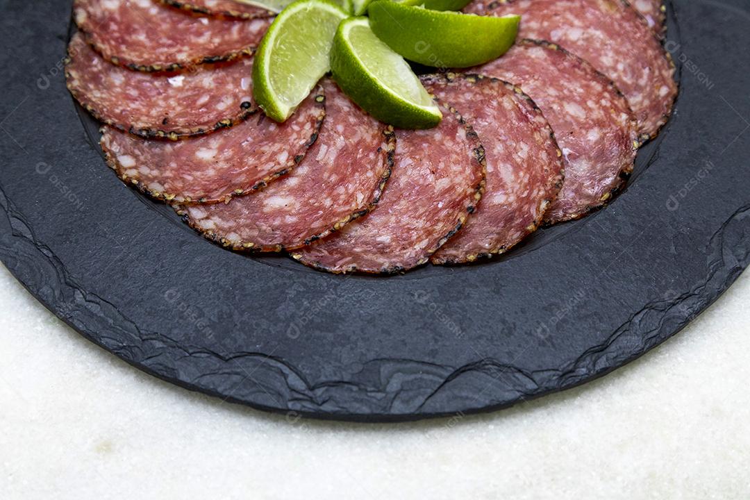 Porção de salame em placa de pedra preta JPG