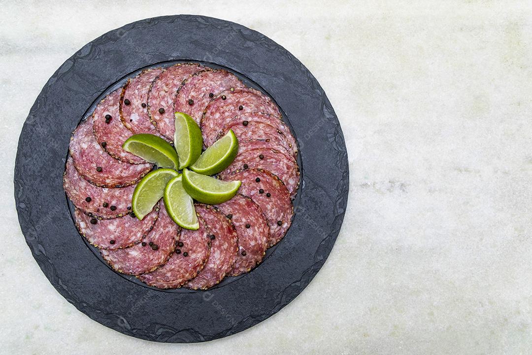 Portion of salami on black stone plate JPG