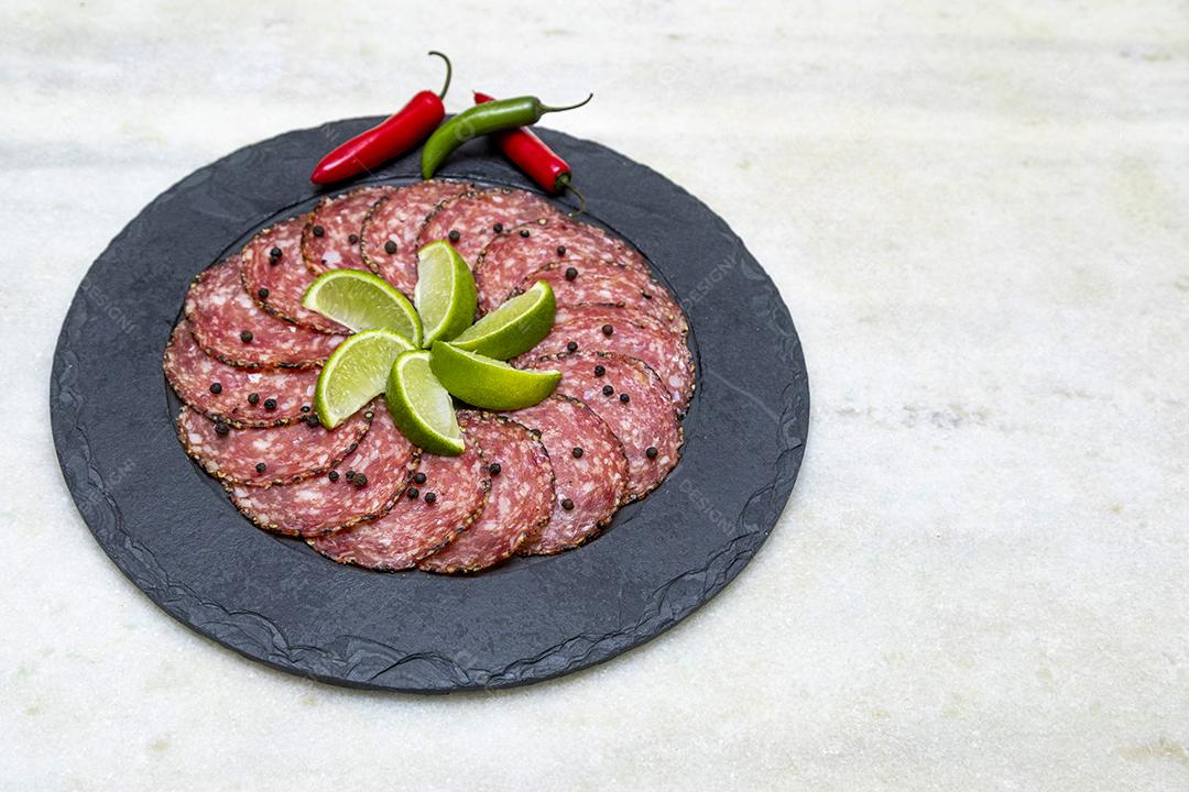 Porção de salame em placa de pedra preta JPG