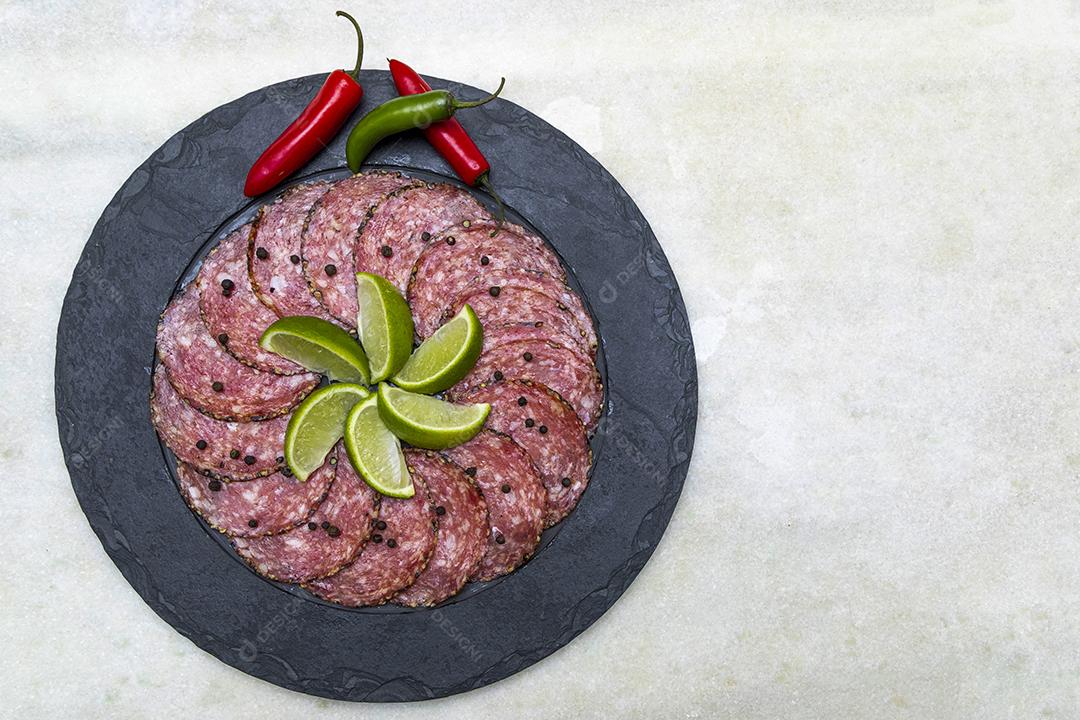 Portion of salami on black stone plate JPG