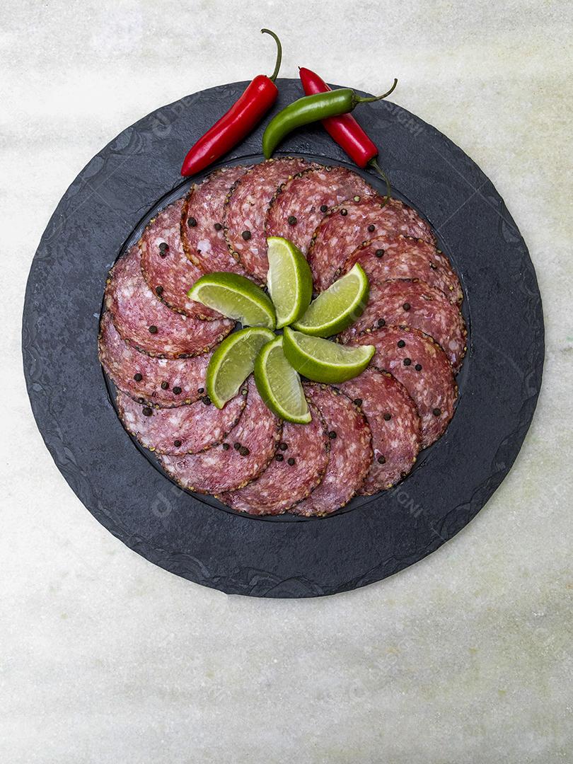Porção de salame em placa de pedra preta JPG