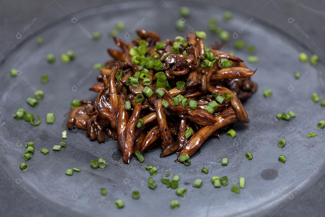 Cogumelo Shimeji servido com cebolinha no prato de pedra preta. Tipica JPG