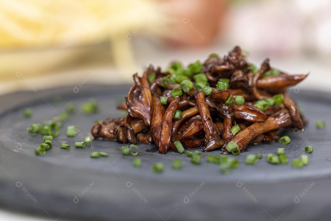 Cogumelo Shimeji servido com cebolinha no prato de pedra preta. Tipica JPG