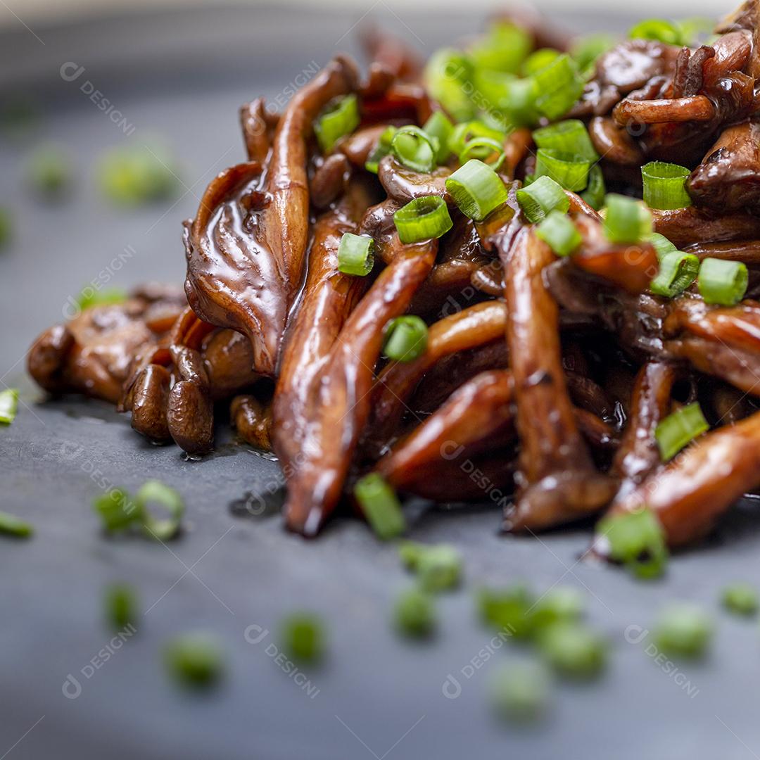 Cogumelo Shimeji servido com cebolinha no prato de pedra preta. Tipica JPG