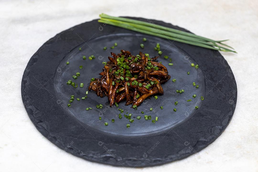 Cogumelo Shimeji servido com cebolinha no prato de pedra preta. Tipica JPG