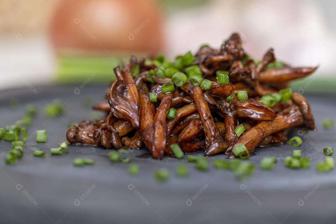 Cogumelo Shimeji servido com cebolinha no prato de pedra preta. Tipica JPG