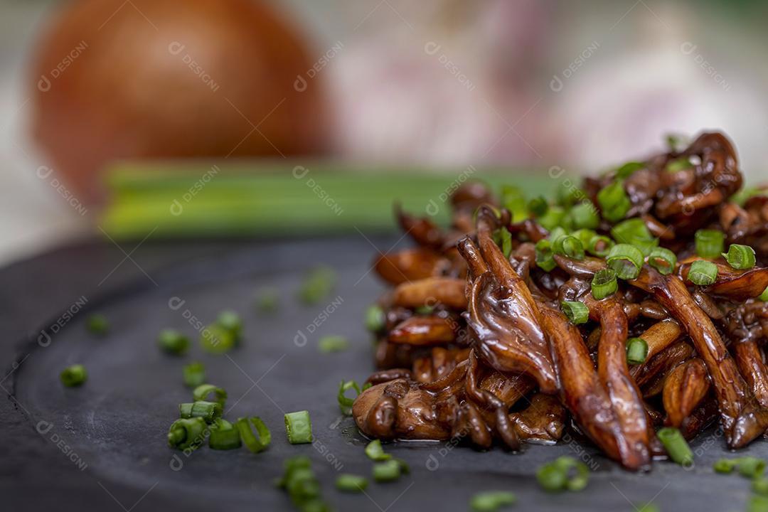 Cogumelo Shimeji servido com cebolinha no prato de pedra preta. Tipica JPG