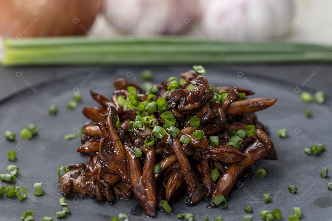 Cogumelo Shimeji servido com cebolinha no prato de pedra preta. Tipica JPG