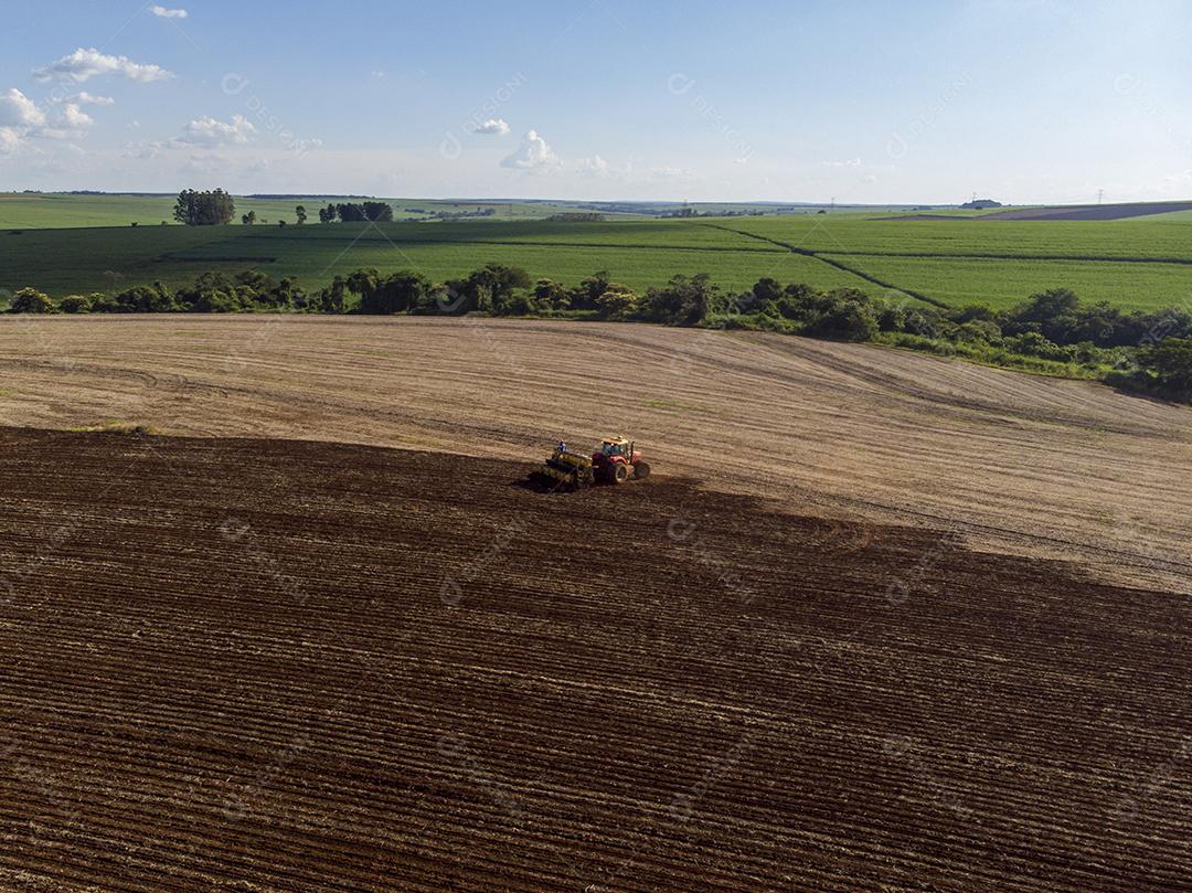 Trator com infiltrado no campo. Semeadura de milho, milho no solo JPG