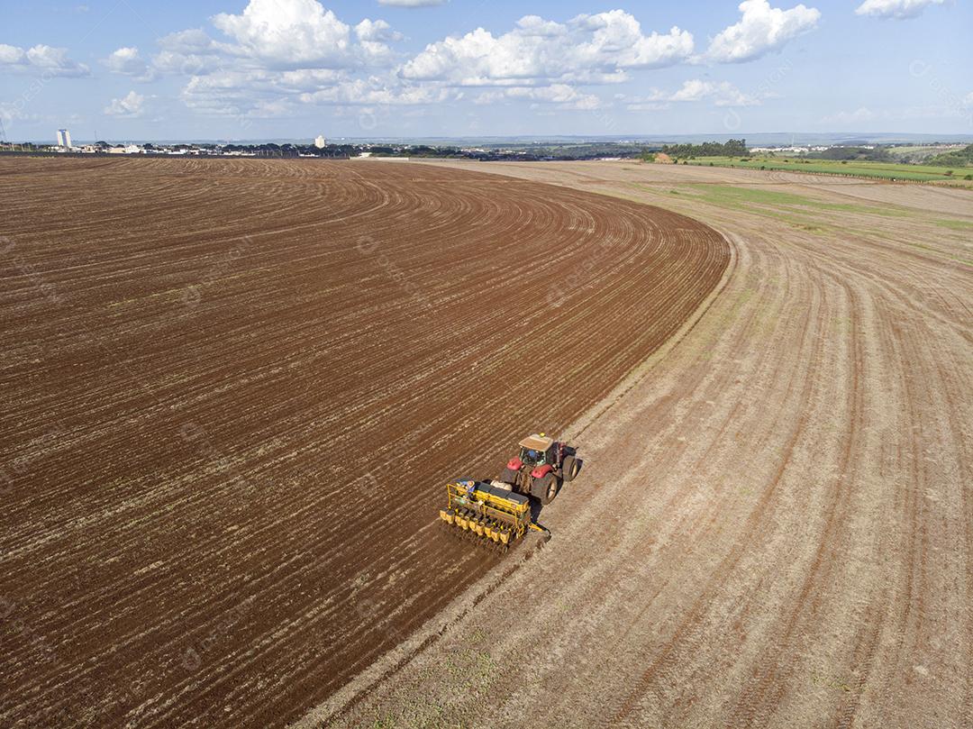 Trator com infiltrado no campo. Semeadura de milho, milho no solo JPG