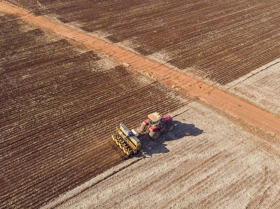 Trator com infiltrado no campo. Semeadura de milho, milho no solo JPG