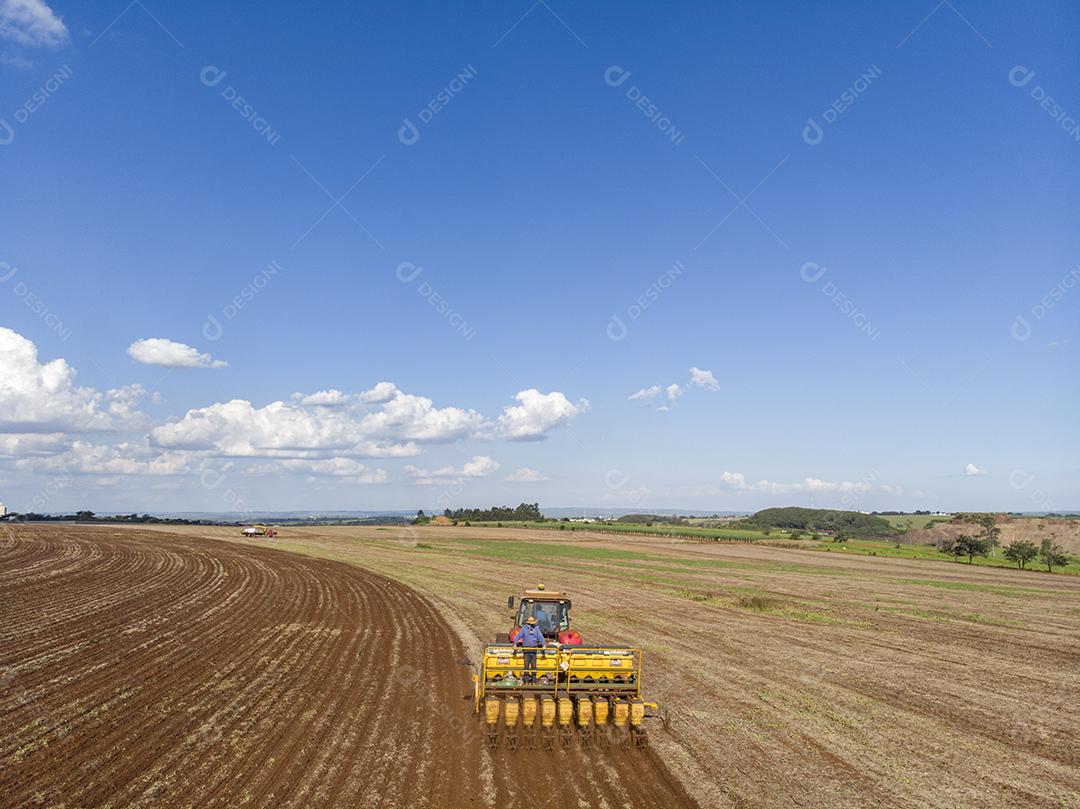 Trator com infiltrado no campo. Semeadura de milho, milho no solo JPG