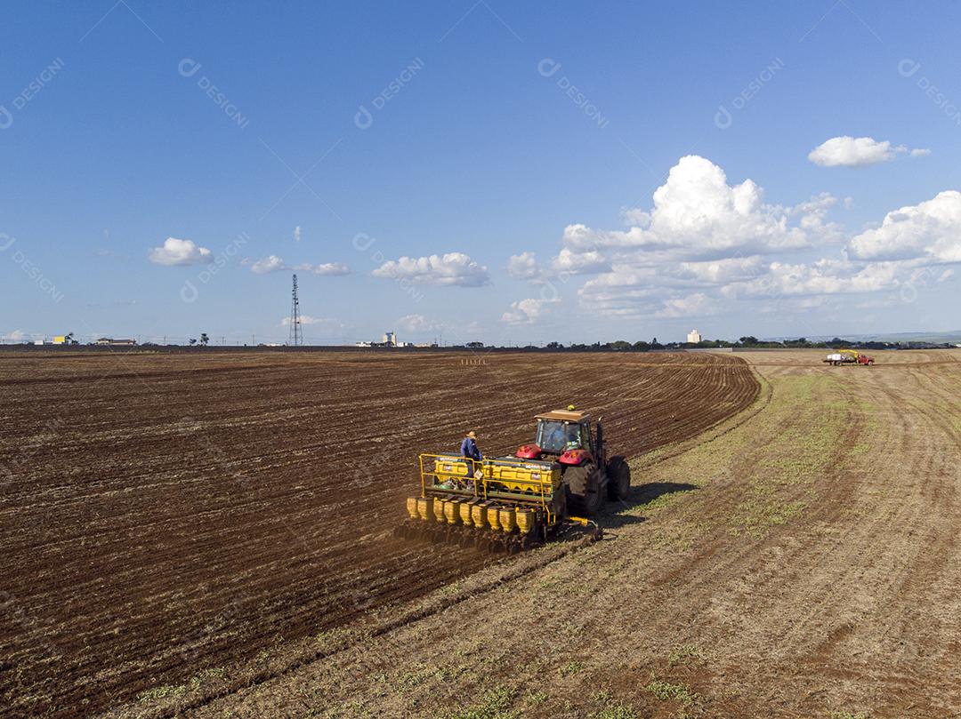 Trator com infiltrado no campo. Semeadura de milho, milho no solo JPG