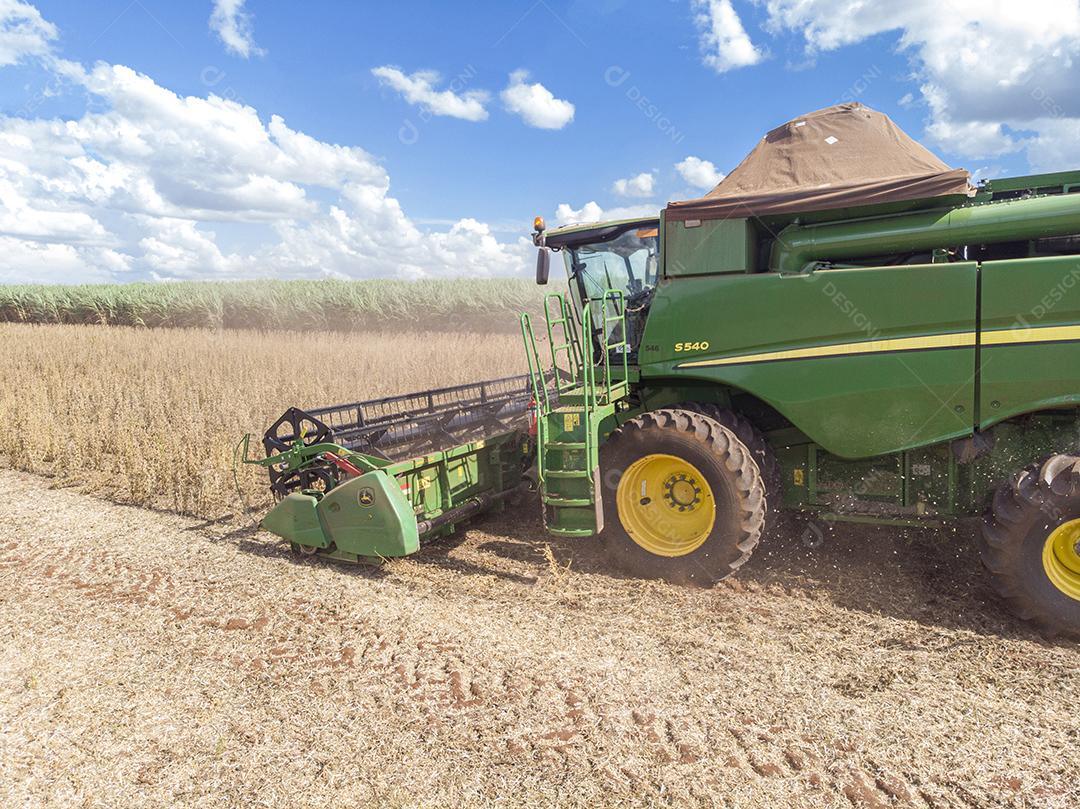 Trator agrícola colhendo soja no campo - Pedernei JPG
