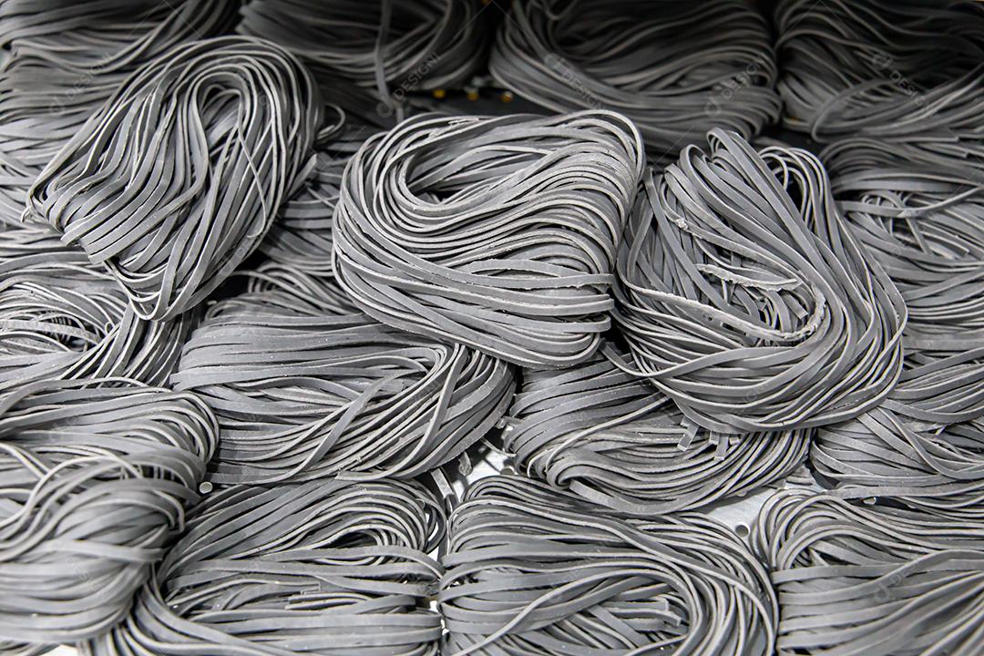 Produção artesanal de macarrão em um restaurante italiano. Macarrão no processo de secagem JPG