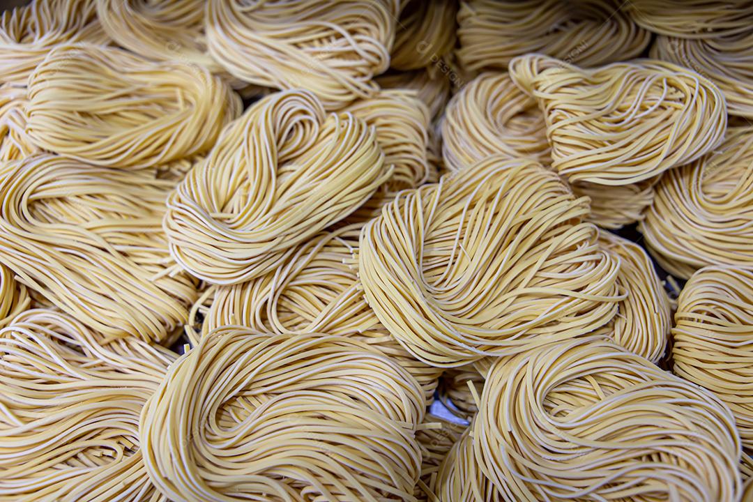 Produção artesanal de macarrão em um restaurante italiano. Macarrão amarelo no processo de secagem JPG