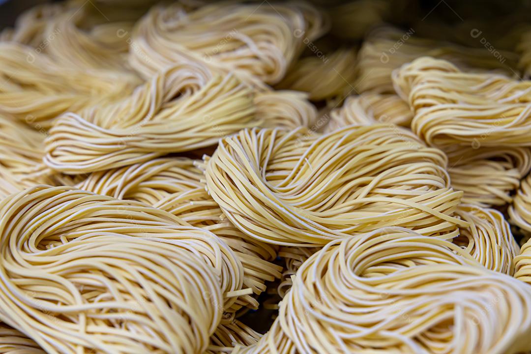 Produção artesanal de macarrão em um restaurante italiano. Macarrão amarelo no processo de secagem JPG