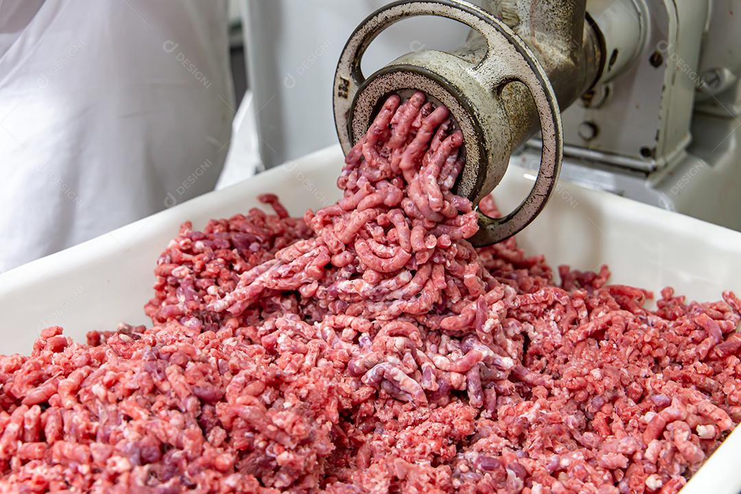 Carne sendo moída em um moedor de carne. Em um restaurante fotos imagens JPG