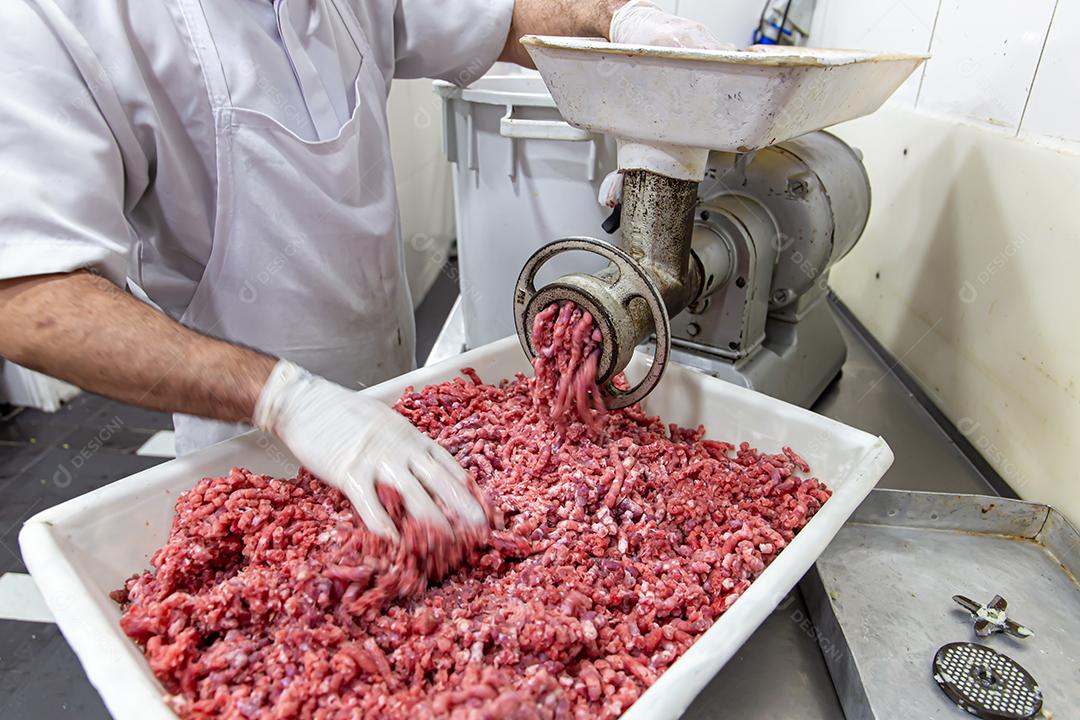 Carne sendo moída em um moedor de carne. Em um restaurante fotos imagens JPG