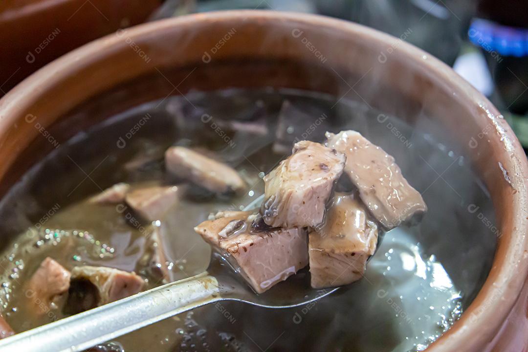 Pote de cerâmica com feijoada, comida típica brasileira. Em um restaurante no Brasil JPG