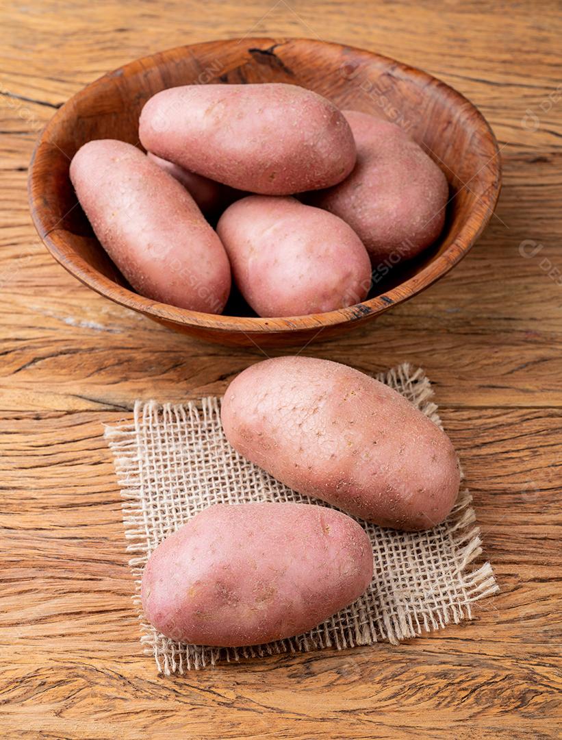 Batata vermelha em uma tigela sobre mesa de madeira JPG