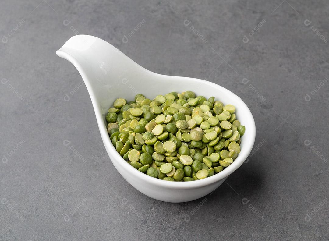 Ervilhas verdes secas cruas em uma tigela sobre fundo de pedra JPG